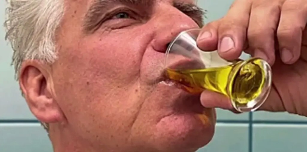 Man drinking his meal-replacement shake from a small glass.